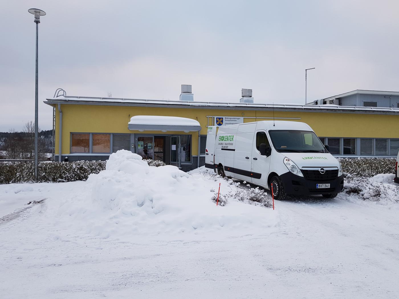 gult lågt hus med en skåpbil utanför