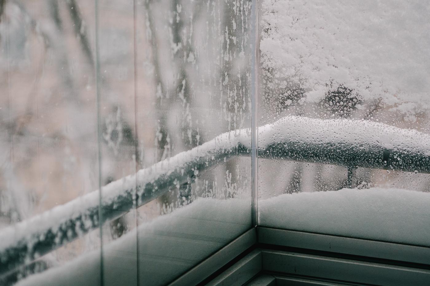 Snö samlat på utsidan av balkongglas