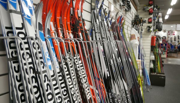 Skidor radade längs vägg i sportaffär.