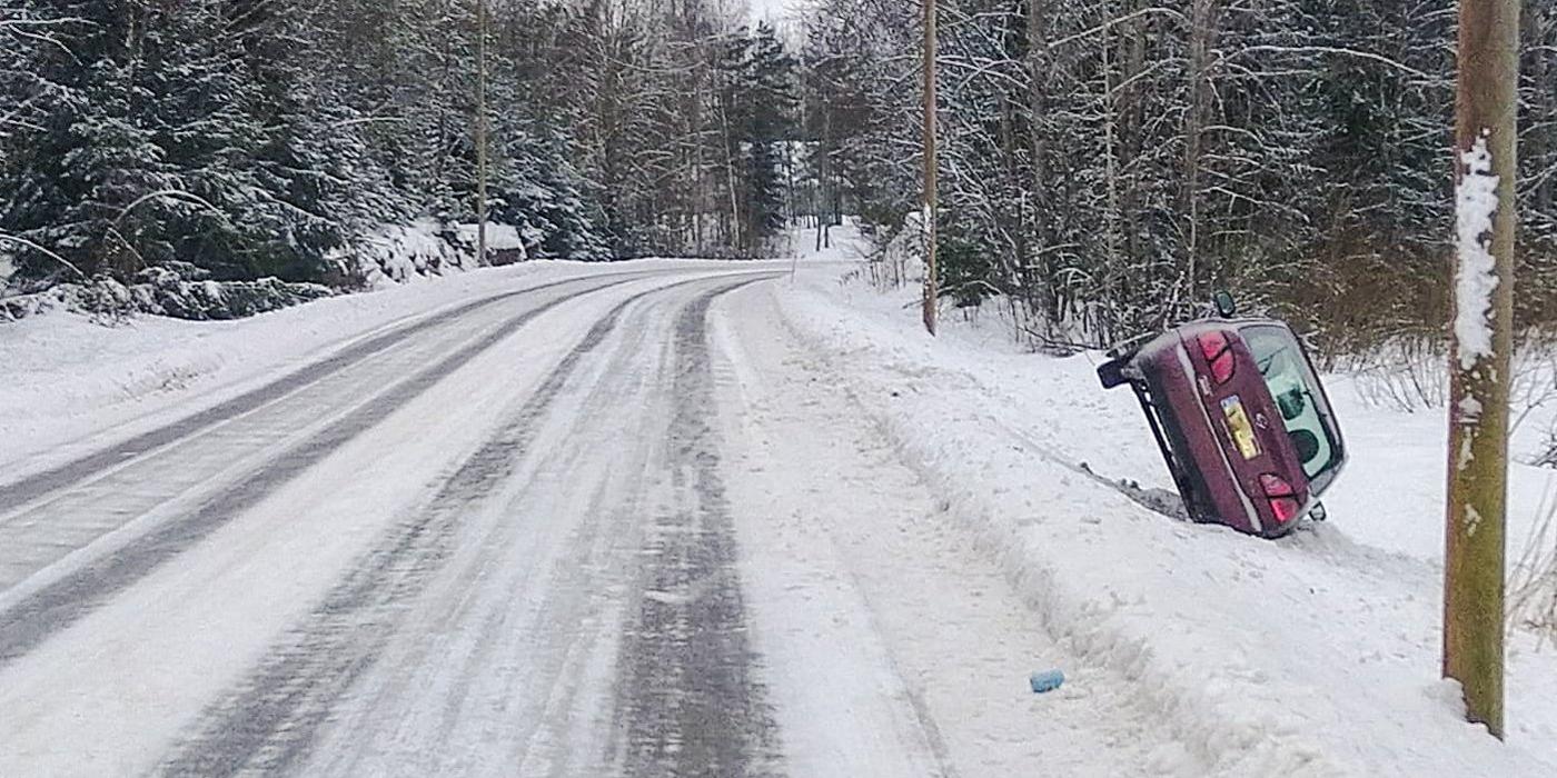 bil i diket vid landsbygdsväg med mycket snö