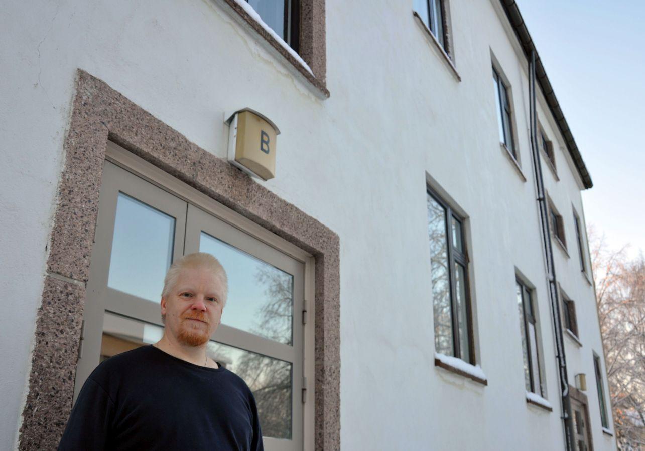 Man står utanför höghusdörr