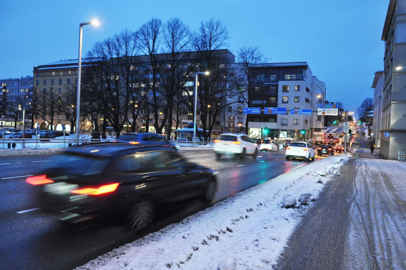 bilar kör längs gata i skymning