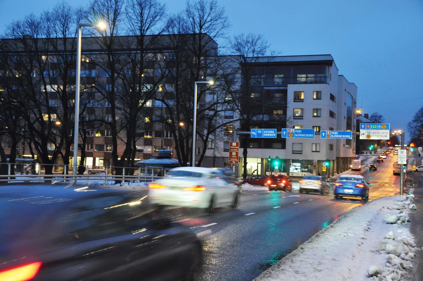 bilar kör längs gata i skymning