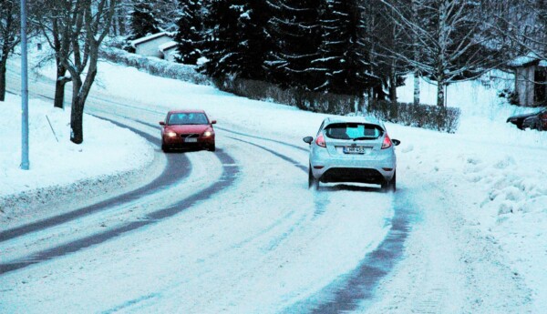bilar kör längs väg i snöföre