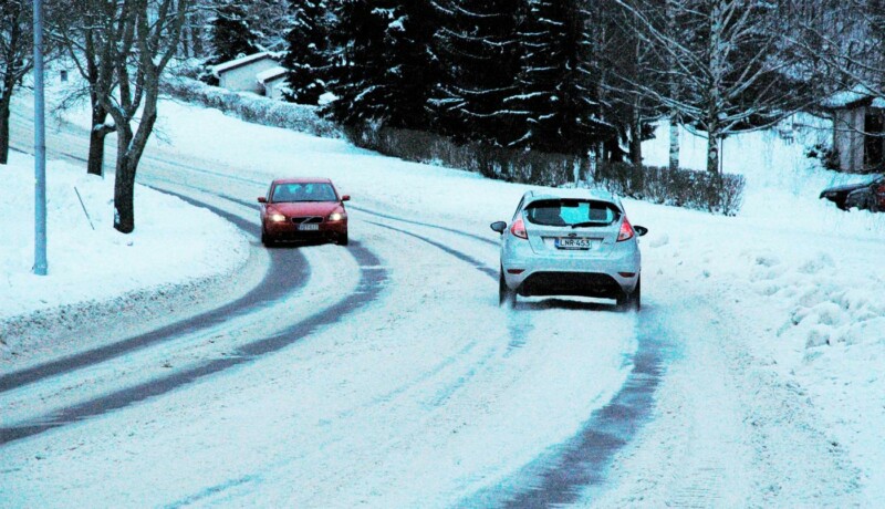 bilar kör längs väg i snöföre