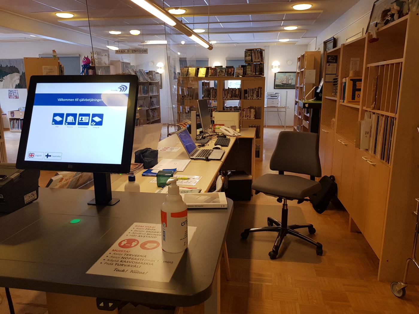 bibliotek med utlångingsapparat i förgrunden
