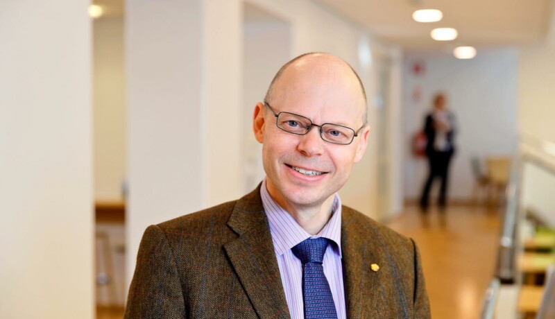 en leende man i glasögon