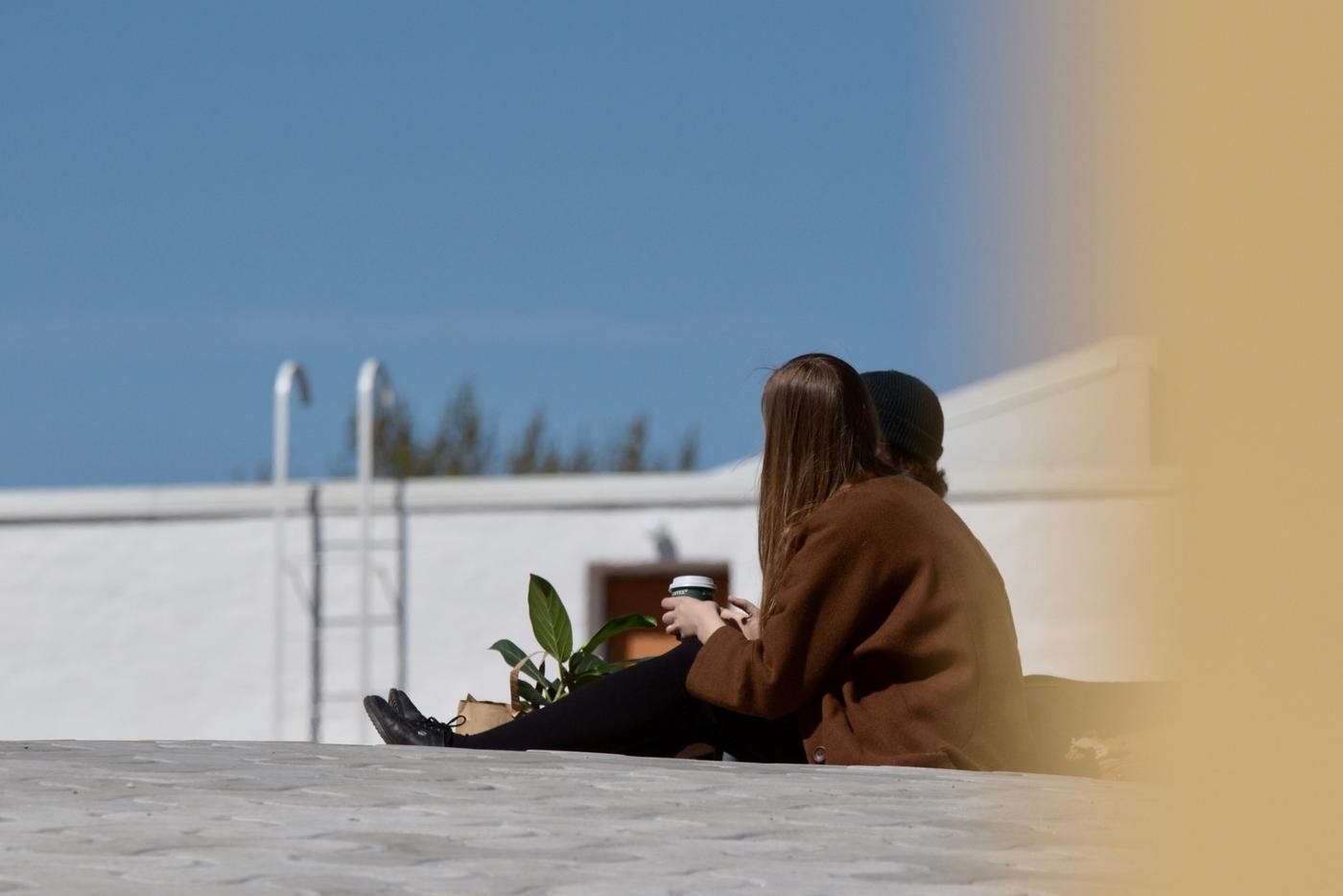 två ungdomar sitter och samtalar kring en kopp kaffe