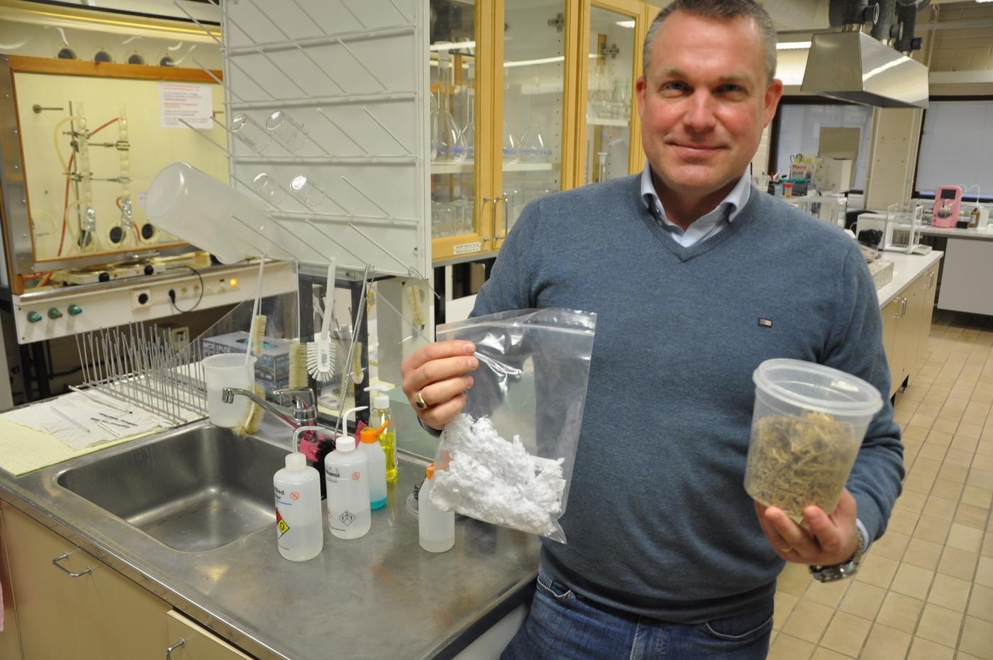 man i laboratorium håller upp en påse med textilfiber tillverkade av halmstrån gjorda visar upp biomassa och