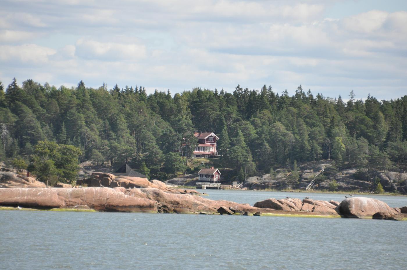 sommarstuga invid en strand med klippor