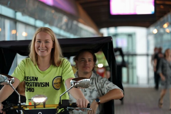 Kvinna som trampar en cykel med en dragkärra bakom.