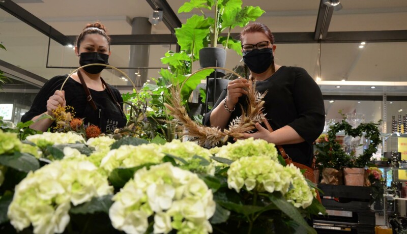 stora blommor framför två kvinnor i en blombutik