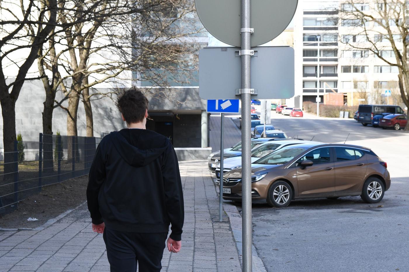 parkerade bilar, en fotgängare och några trafikmärken