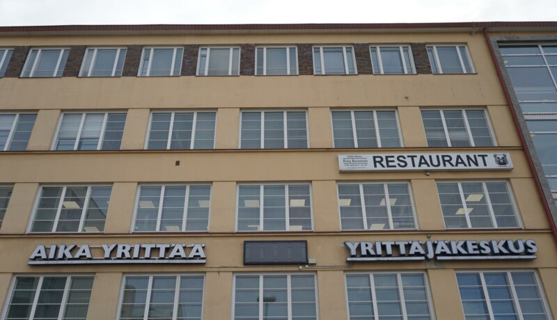 en vägg med en skylt: aika yrittää, yrittäjät