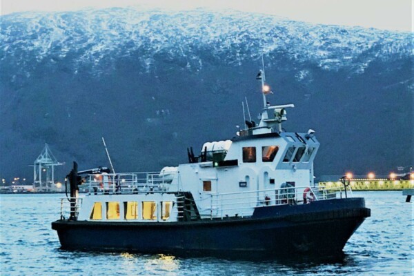 ett svartvitt fartyg i en fjord