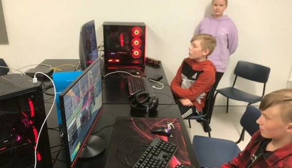 Barn sitter och spelar datorspel