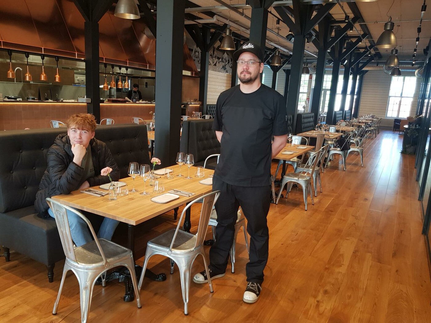 två killar i en restaurang med brunt golv