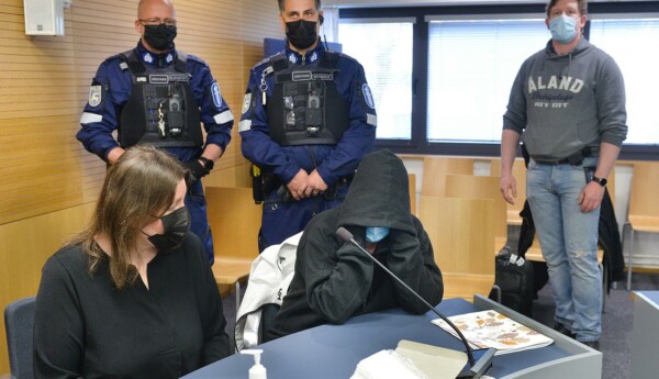 Två kvinnnor döljer sina ansikten på en rättegång
