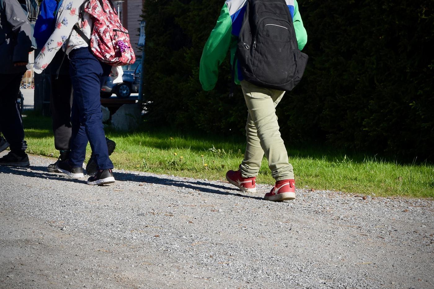 skolelev går med ryggsäck på ryggen