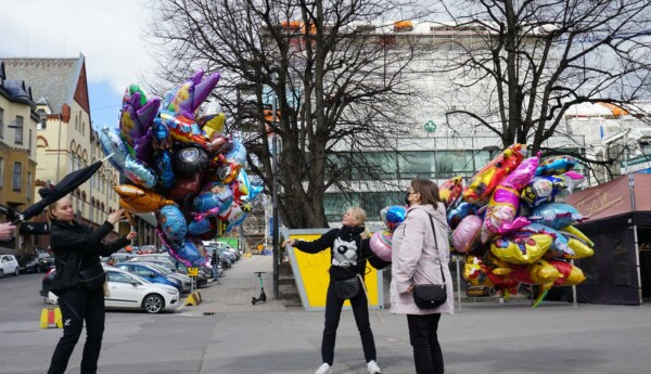 två personer säljer heliumballonger