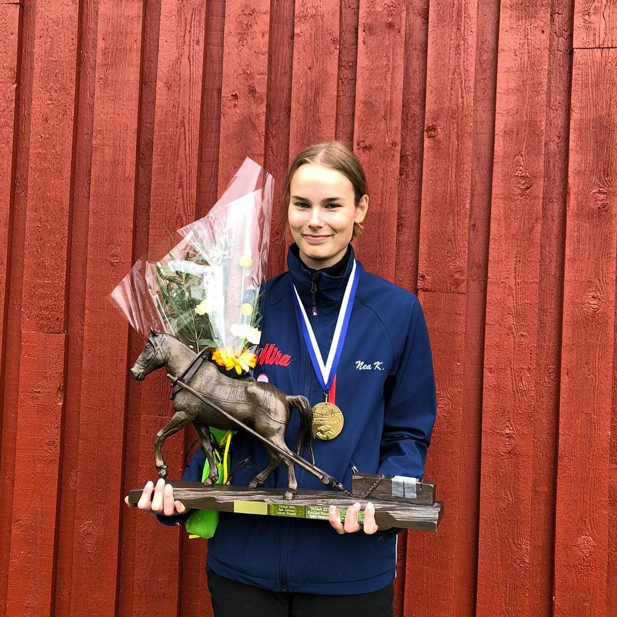 Ung dam med blommor, medalj och en pokal