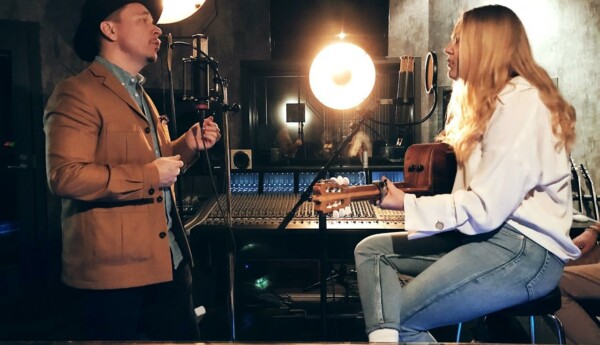 man och kvinna sjunger och spelar gitarr