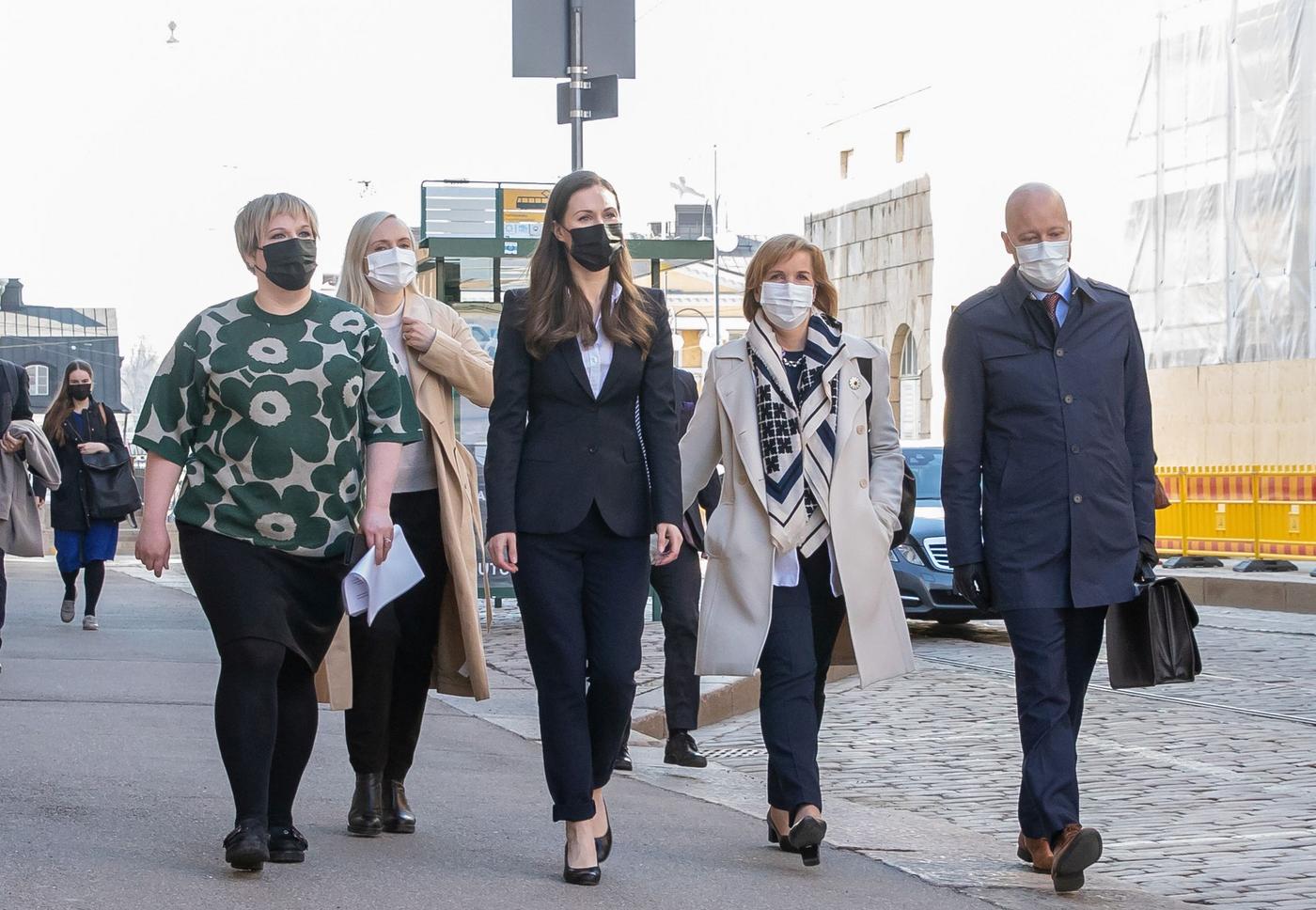 Tre kvinnor och en man går på trottoar