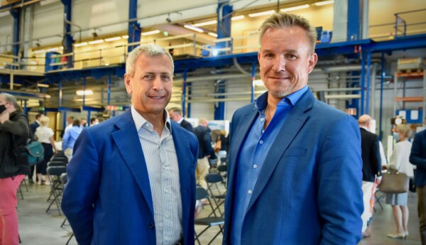 Två män iklädda kavajer ler mot kameran.