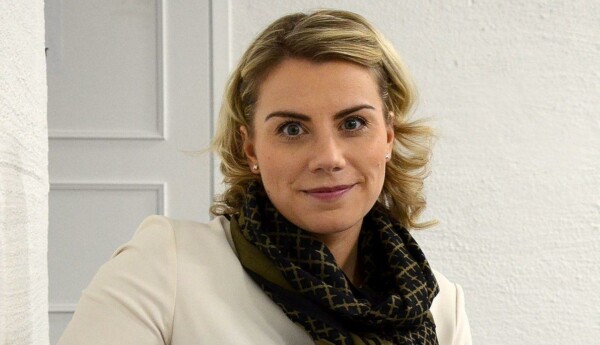 Kvinna lutar sig tillbaka i soffa