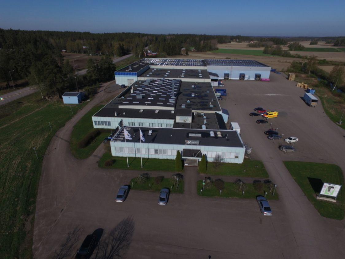 en fabrik omgiven av skog