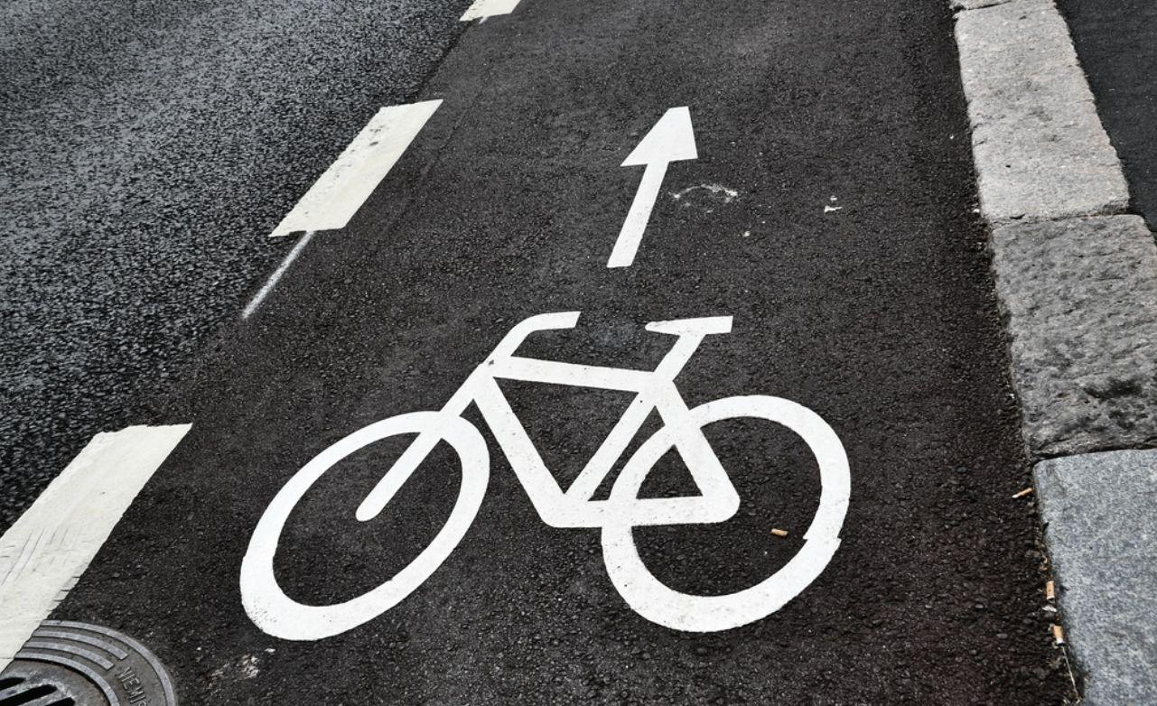 en svart väg med en vit målad cykel på