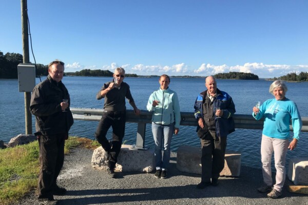 Personer uppställda på rad med havet i bakgrunden.
