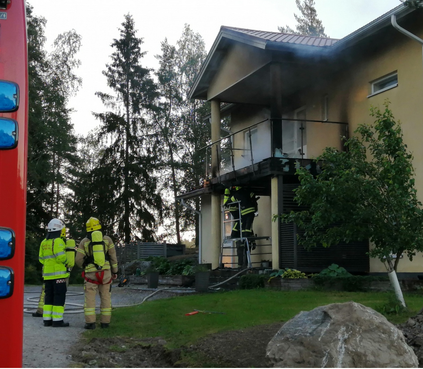 en bralkong som precis brunnit på ett egnahemshus, brandpersonal står nedanför
