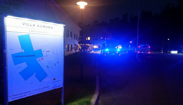 en skylt, blåljus i bakgrunden