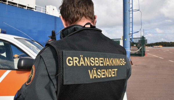 En man iklädd uniform fotad bakifrån. På uniformen står "Gränsbevakningsväsendet",