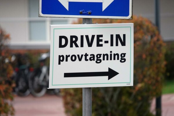 En skylt med en pil och texten "Drive-in provtagning".