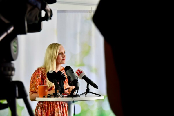 En kvinna står vid ett podium och talar.