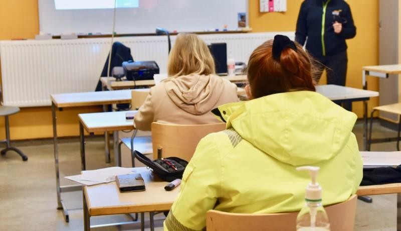 Skolelever sitter i ett klassrum vid pulpeter.