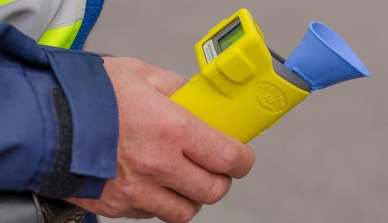 En hand håller i en alkometer.
