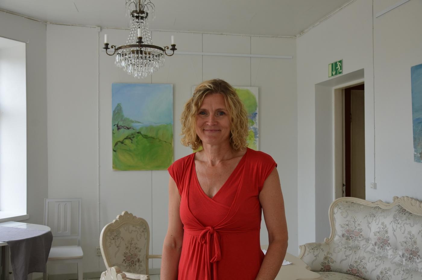 leende kvinna framför målningar