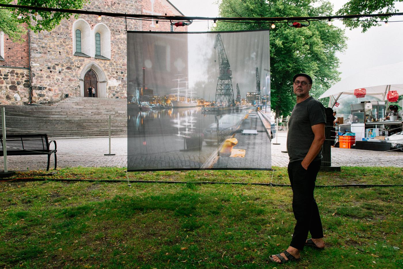 En man vid ett stort fotografi i en park.