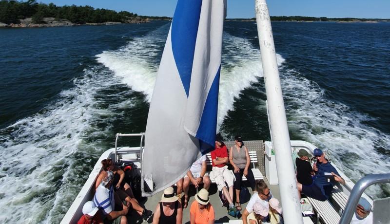människor sitter i aktern på charterbåt en varm sommardag