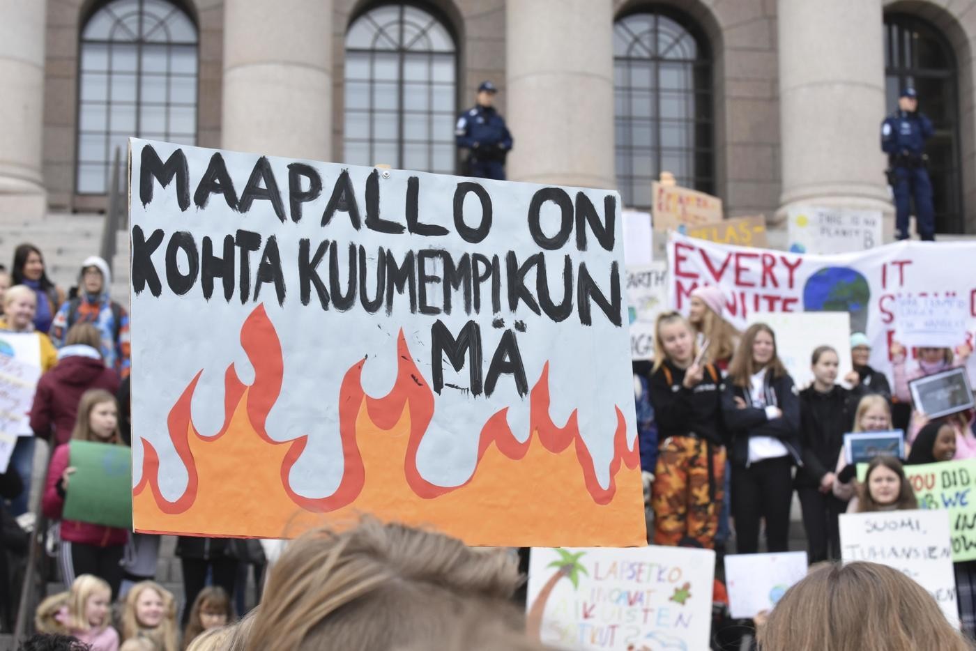 Människor som demonstrerar med ett stort plakat.