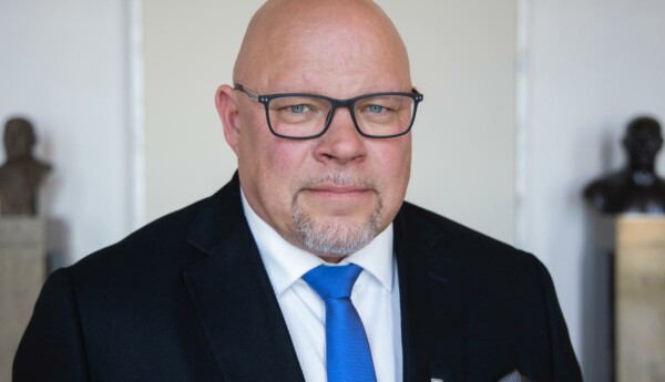 Mn med kostym och glasögon.