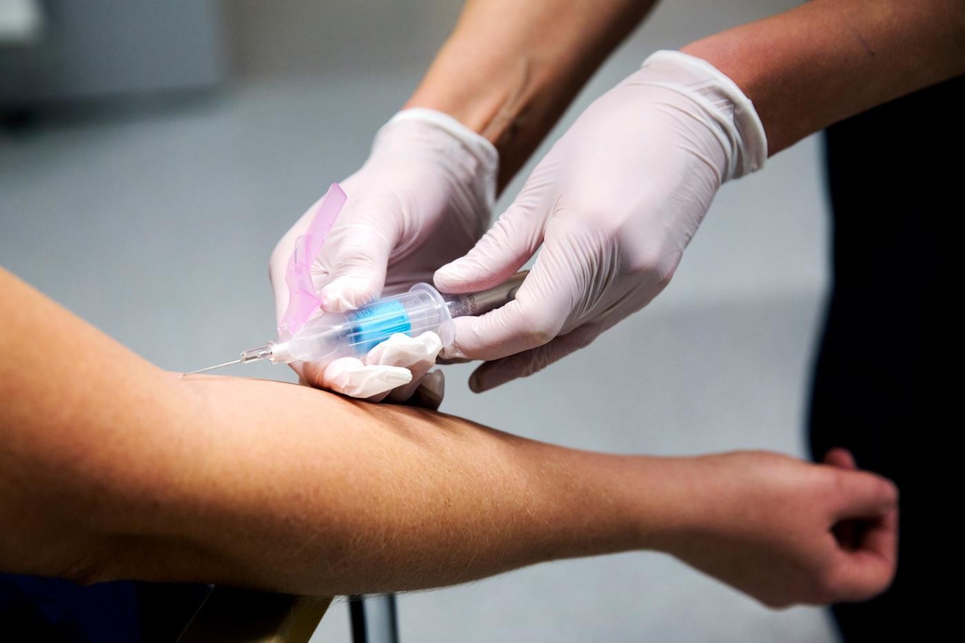 Ett par händer som vaccinerar en arm.