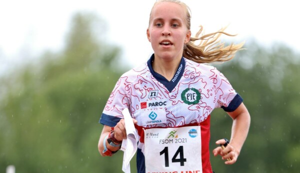En kvinna springer med karta i handen och nummerlapp på dräkten.