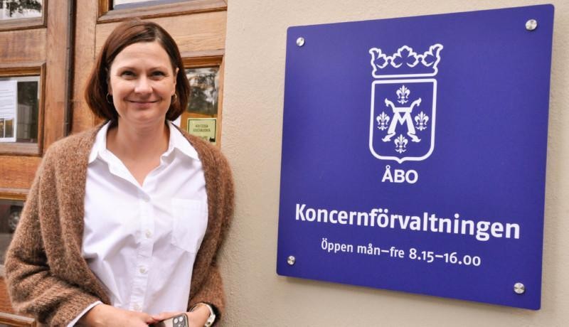 En kvinna står framför en dörr