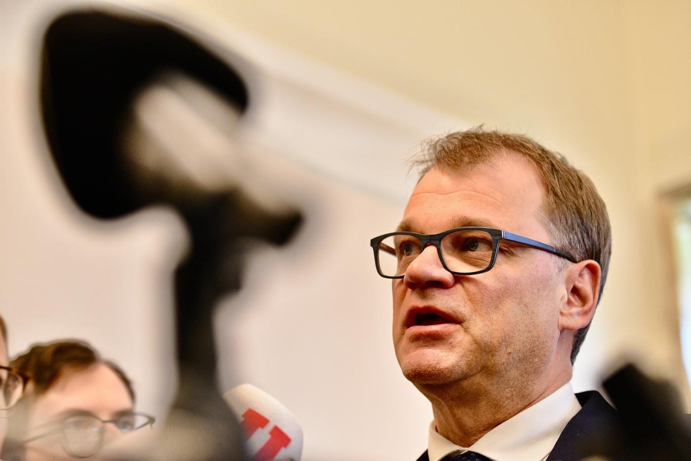man med glasögon framför mikrofoner