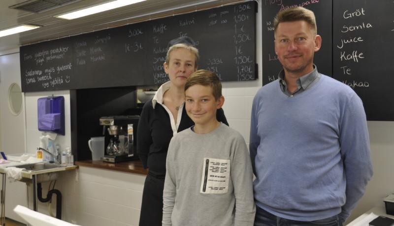 tre personer bakom disken i ett café