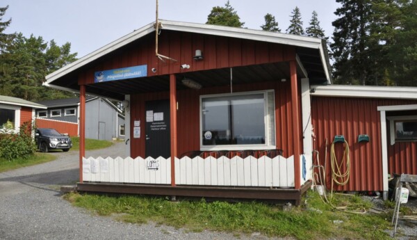Liten röd stuga med vitt staket